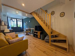 a living room with a staircase and a couch at Le Clos Macé - Maison d'hôtes proche BLOIS CHAMBORD in Saint-Denis-sur-Loire
