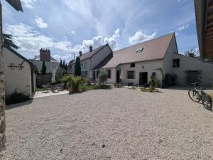 a house with a gravel driveway in front of it at Le Clos Macé - Maison d'hôtes proche BLOIS CHAMBORD in Saint-Denis-sur-Loire