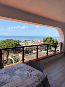 a bedroom with a balcony with a view of the ocean at Nora's Flats in Triscina +51 photos
