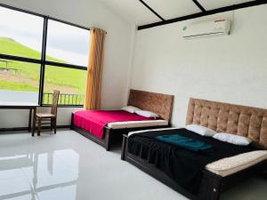 a bedroom with two beds and a couch and a window at N4 Rest Hanthana in Etulgama