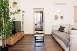 a living room with a couch and a tv at Appart Cosy I Centre-ville in Istres