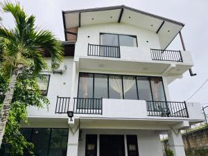 a white building with balconies and a palm tree at N4 Rest Hanthana in Etulgama +12 photos