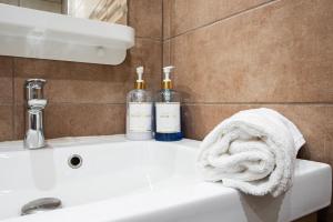 two bottles of wine sitting on top of a bathroom sink at Appart Cosy I Centre-ville in Istres +15 photos