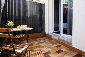 a patio with a table and chairs on a balcony at Appart Cosy I Centre-ville in Istres