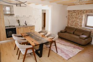 a kitchen and living room with a wooden table and chairs at Aurora in Ljubuški