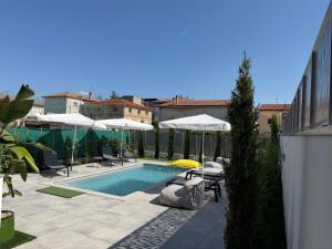 a swimming pool with umbrellas and chairs next to a building at D'ANNUNZIO suites in Martinsicuro