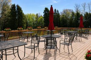 a group of tables and chairs with red umbrellas at Hôtel au Petit Berger in La Malbaie