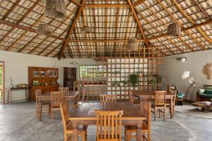 a dining room with wooden tables and chairs at Reserva Pratigi in Ituberá
