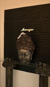 a statue of a head on top of a shelf at Marujo Home & Heart in Penedo Gordo