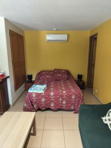 a bedroom with a bed with a red bedspread at Les Buis in Carpentras
