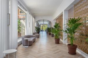 ein Flur mit Topfpflanzen in einem Gebäude in der Unterkunft Hotel Cap Roig & Spa by Brava Hoteles in Platja  d'Aro