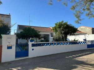 a blue and white fence in front of a house at Marujo Home & Heart in Penedo Gordo