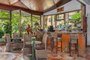 eine Bar in einem Restaurant mit Tischen und Stühlen in der Unterkunft Hotel Cap Roig & Spa by Brava Hoteles in Platja  d'Aro