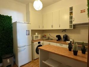 a kitchen with a white refrigerator and a sink at Marujo Home & Heart in Penedo Gordo