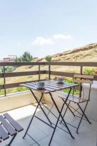 a table and two chairs on a balcony at Saint Paul Guesthouse in Zahlé