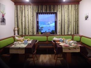a dining room with two tables and a window at Haus Ratgeb in Filzmoos