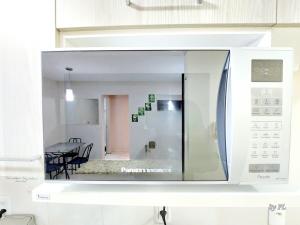 a white microwave oven with a kitchen in the background at Graciosa Reserva Ipanema in Porto Alegre +46 photos