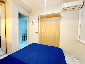 a bedroom with a blue bed and a door at Graciosa Reserva Ipanema in Porto Alegre