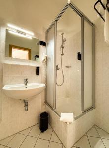 a bathroom with a sink and a shower at Hotel Schillerbad in Lüdenscheid