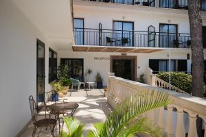 a balcony of a building with tables and chairs at Hotel Playa Mondrago in Portopetro