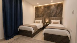 two beds in a small room with blue curtains at Sol Pyramids Rooftop View Giza in Cairo