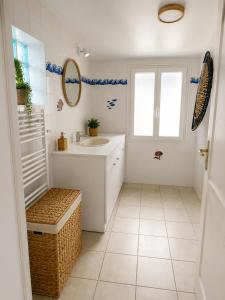 a white bathroom with a sink and a mirror at La Tropicale - Terrasse Privée Entre Lac & Océan- C' LA VIEconciergerie in Soustons +16 photos
