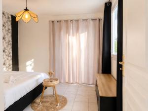 a bedroom with a bed and a table and a window at La Tropicale - Terrasse Privée Entre Lac & Océan- C' LA VIEconciergerie in Soustons