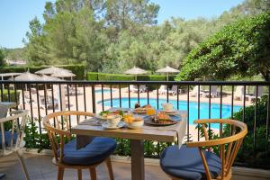 a table with food on it next to a pool at Hotel Playa Mondrago in Portopetro