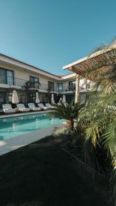 a resort with a swimming pool and chairs and a building at Wakana Alaçatı in Alaçatı