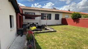 a backyard of a house with a yard with a patio at Chez Emma in Niort