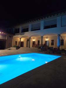 a large swimming pool lit up at night at Dimora Federica in Erbusco