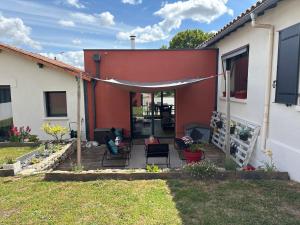 a patio with chairs and an umbrella on a house at Chez Emma in Niort +3 photos