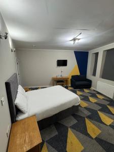 a bedroom with a bed and a couch and a tv at Dream Hotel in Manchester +12 photos