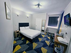 a small room with a bed and a table and a chair at Dream Hotel in Manchester
