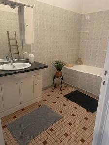 a bathroom with a sink and a bath tub at Maison de campagne in Clessé +6 photos
