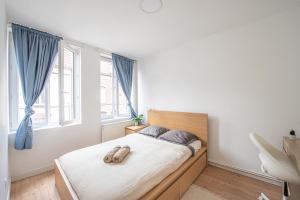 a bedroom with a bed with two slippers on it at Maison Cuvier - Spacieuse Maison Idéale Groupes & Pros in Roubaix