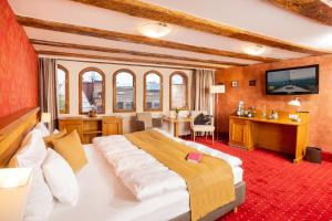 a hotel room with a large bed and a television at Scheelehof - Ein Lieblingsplatz Hotel in Stralsund