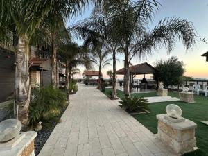 a walkway with palm trees in a resort at carmel cabins suite 7 in Yājur