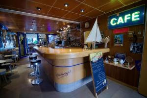a bar in a restaurant with a cafe sign and stools at Hotel Arcantis Le Voltaire in Rennes +12 photos