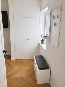 a white room with a stool and a white cabinet at Wake&wave in Užpelkiai