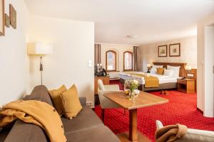 a living room with a couch and a bed at Scheelehof - Ein Lieblingsplatz Hotel in Stralsund