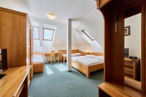 a bedroom with a bed and a dining room at Hotel Krakonoš in Trutnov +10 photos