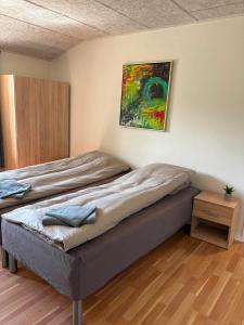 ein Bett in einem Zimmer mit einem Gemälde an der Wand in der Unterkunft Room for rent Landsbyen in Videbæk