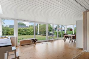a living room with a table and chairs and windows at OH593-Hadsund-Halvrebene-124 in Hadsund +15 photos