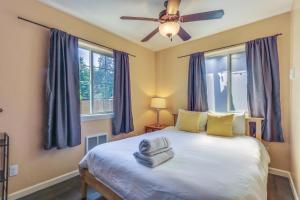 a bedroom with a bed with a ceiling fan and windows at The Nook in Coeur d'Alene +16 photos