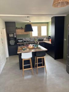 a kitchen with a island with two bar stools at Chez Emma in Niort