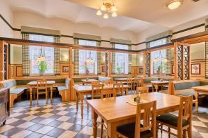 a restaurant with tables and chairs and windows at Hotel Krakonoš in Trutnov