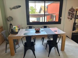 a table and chairs in a kitchen with a window at Chez Emma in Niort