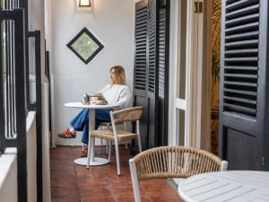 a woman sitting at a table in a room at Nomad City Suites in Cape Town
