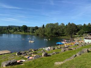 a group of people laying on the grass near a lake at Tiny House Hameln in Salzhemmendorf